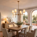 Round Metal Arm Tapered Shade Chandelier above a dining table at golden hour