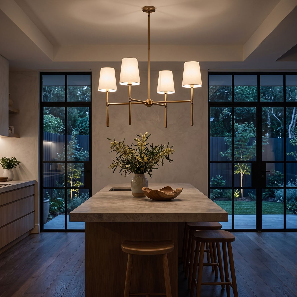 Round Metal Arm Tapered Shade Chandelier above a kitchen island at night