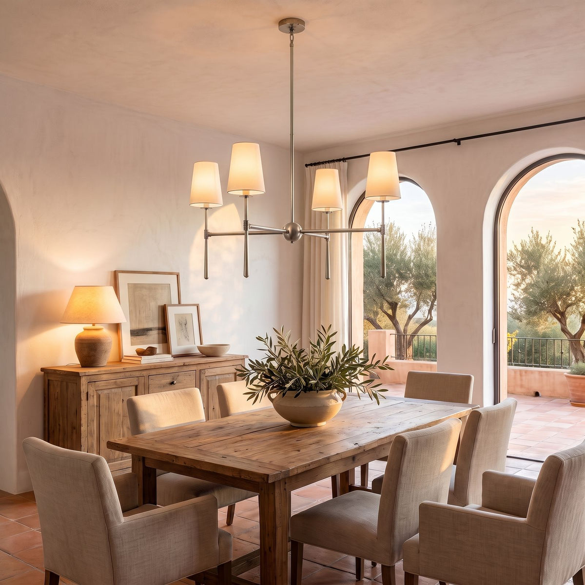 Round Metal Arm Tapered Shade Chandelier in nickel above a dining table at golden hour
