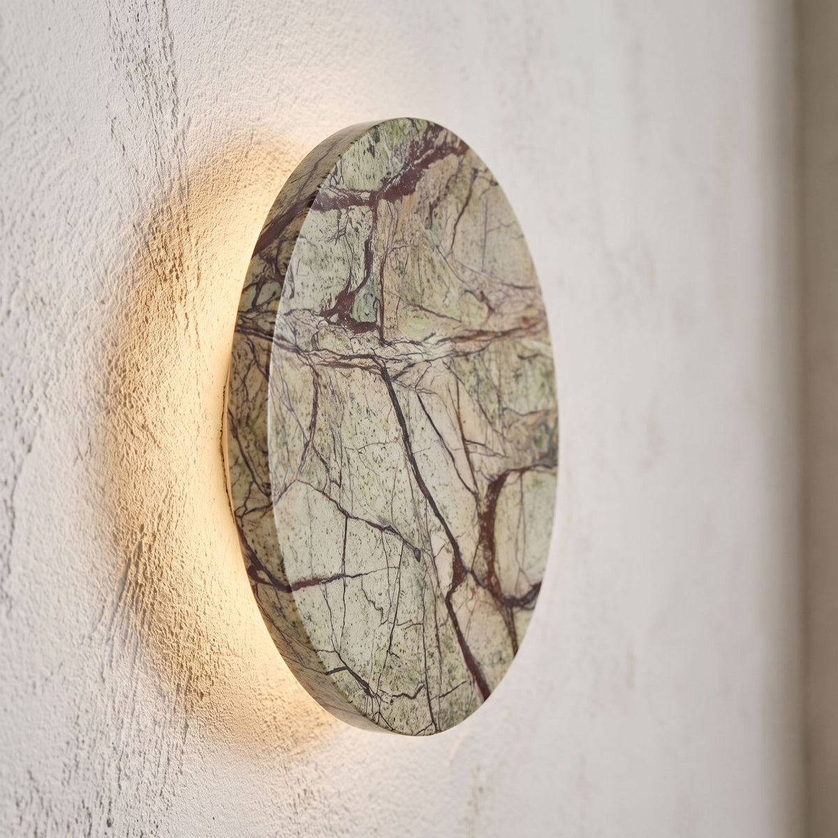 Round Natural Marble LED Wall Light, close view at 45 degrees on a plaster wall