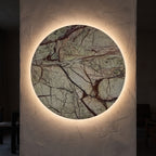 Round Natural Marble LED Wall Light glowing on a plaster wall at night
