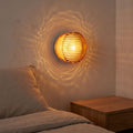 Round Ribbed Glass LED Wall Light beside a bed