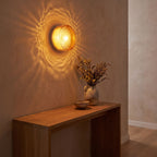 Round ribbed amber glass wall light above an entry console