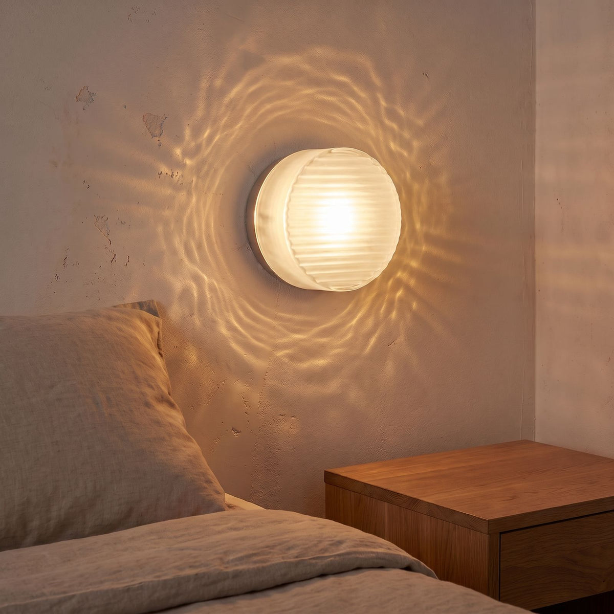 Round Ribbed Glass LED Wall Light with white glass beside a bed
