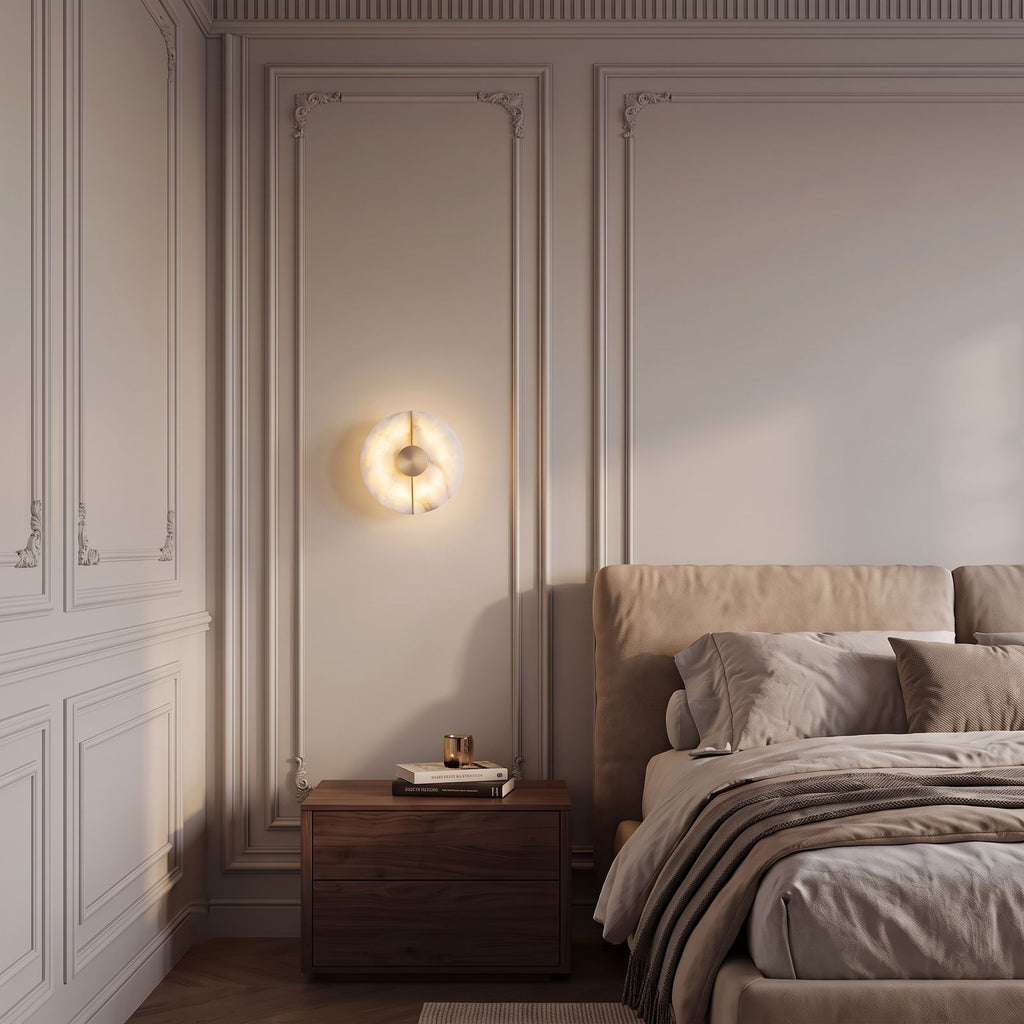 Round Split Marble Disc LED Wall Light on a panelled bedroom wall above a walnut bedside table in the evening