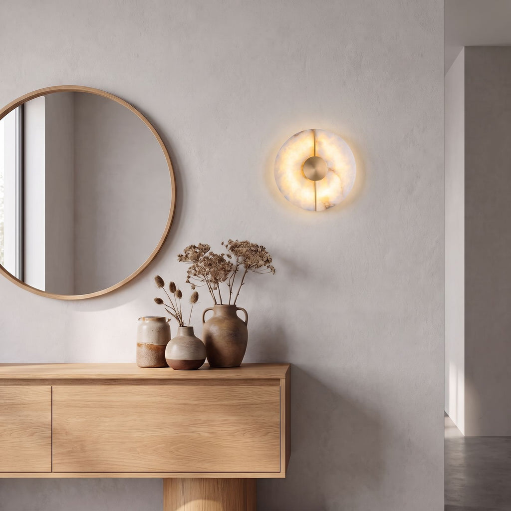 Round Split Marble Disc LED Wall Light beside a round mirror above an oak console in an entrance foyer in daylight