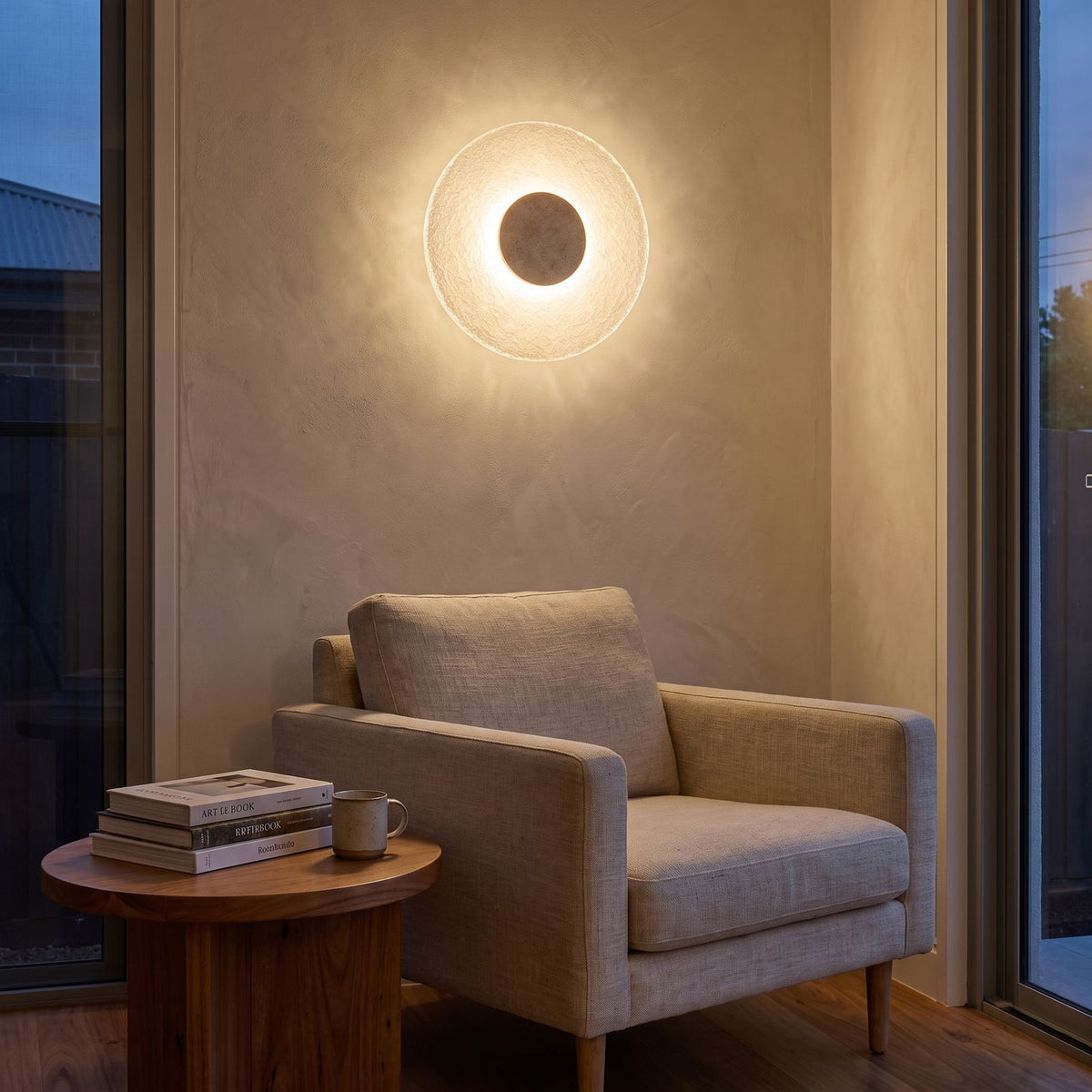 Round Travertine and Acrylic Wall Light above an armchair in a reading corner