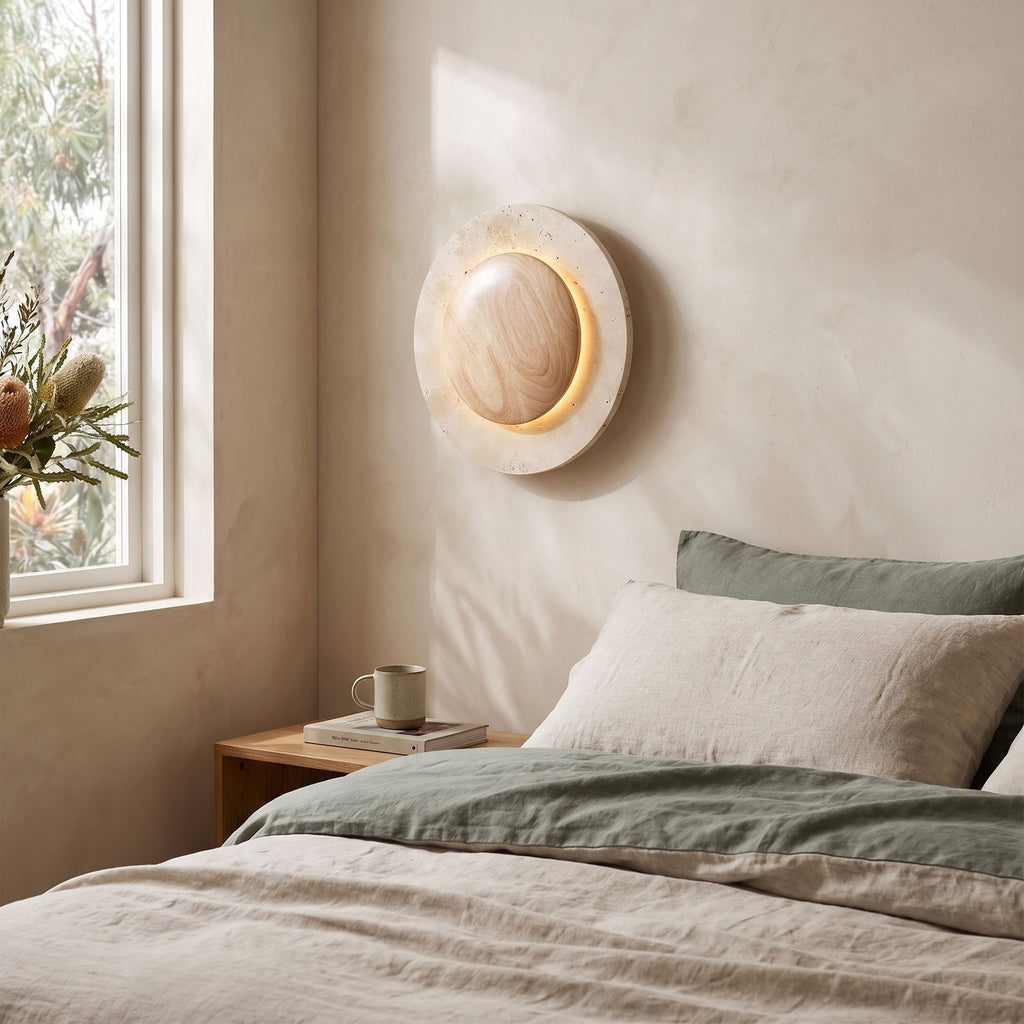 Round Travertine and Wood Shade LED Wall Light on a bedroom wall beside the bed