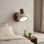 Round Travertine Swivel Bedside Wall Light on a bedroom wall beside the bed