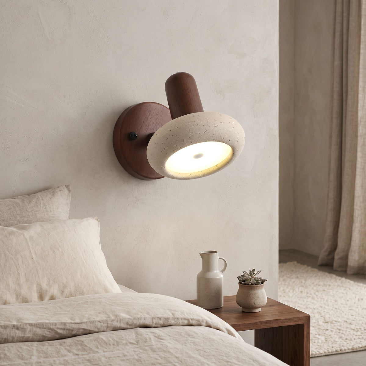 Round Travertine Swivel Bedside Wall Light on a bedroom wall beside the bed