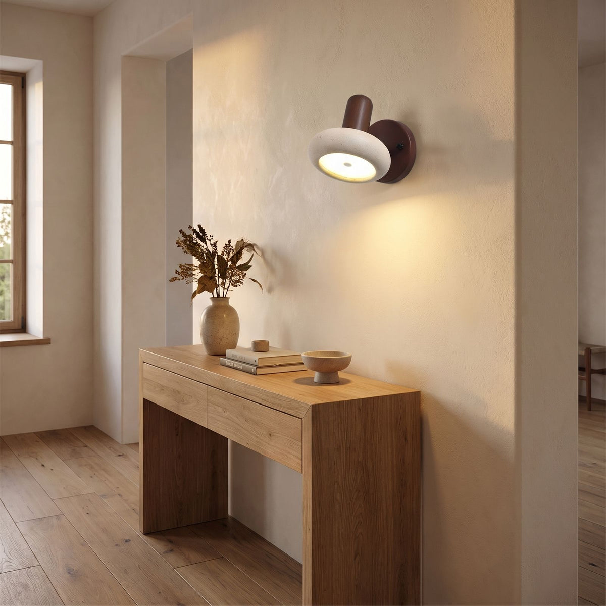 Round Travertine Swivel Bedside Wall Light in a hallway above a timber console