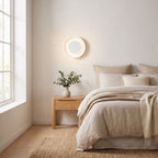 Round White Gypsum and Acrylic Wall Light on a bedroom wall beside the bed