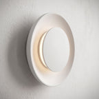 Round White Gypsum and Acrylic Wall Light, close view at 45 degrees on a plaster wall
