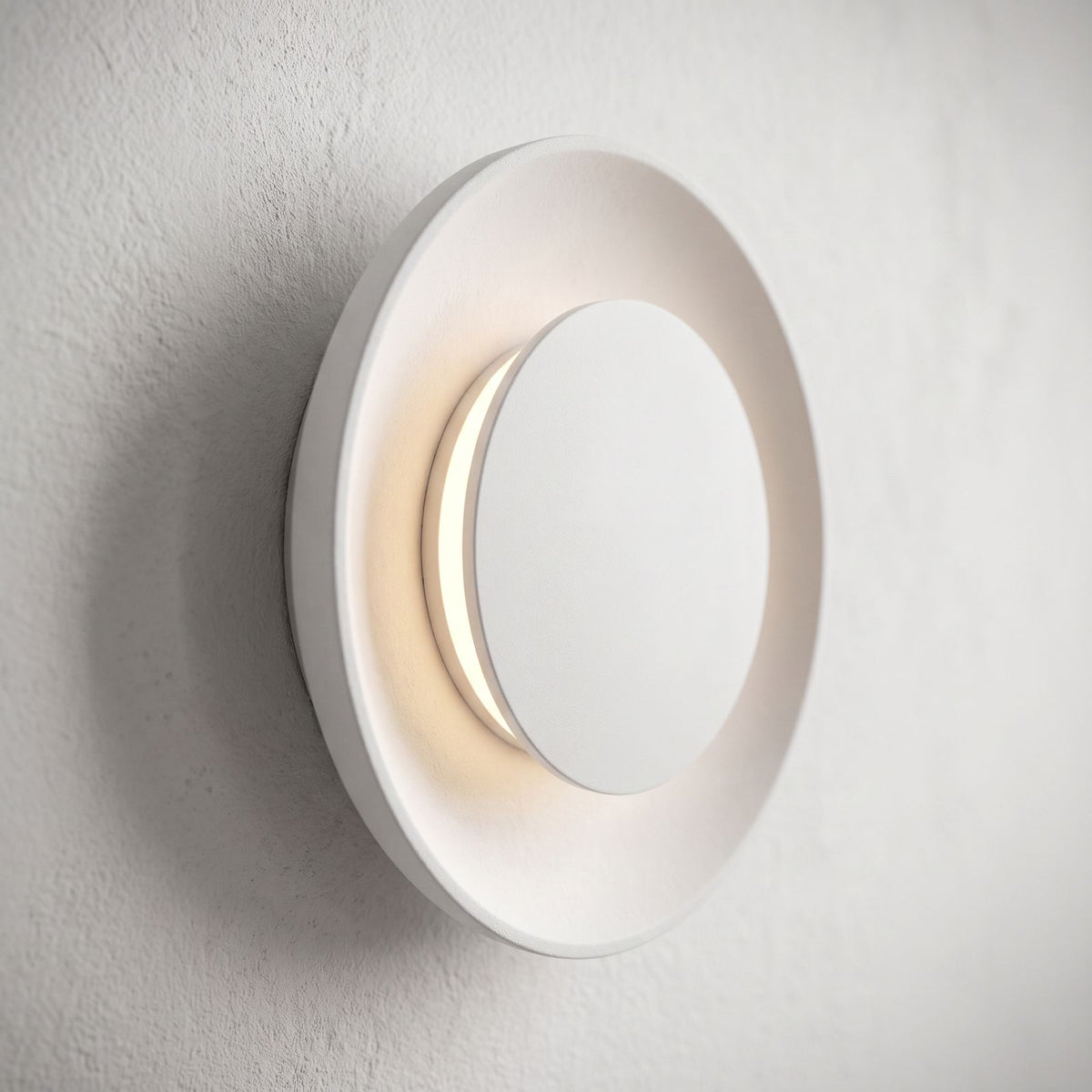 Round White Gypsum and Acrylic Wall Light, close view at 45 degrees on a plaster wall