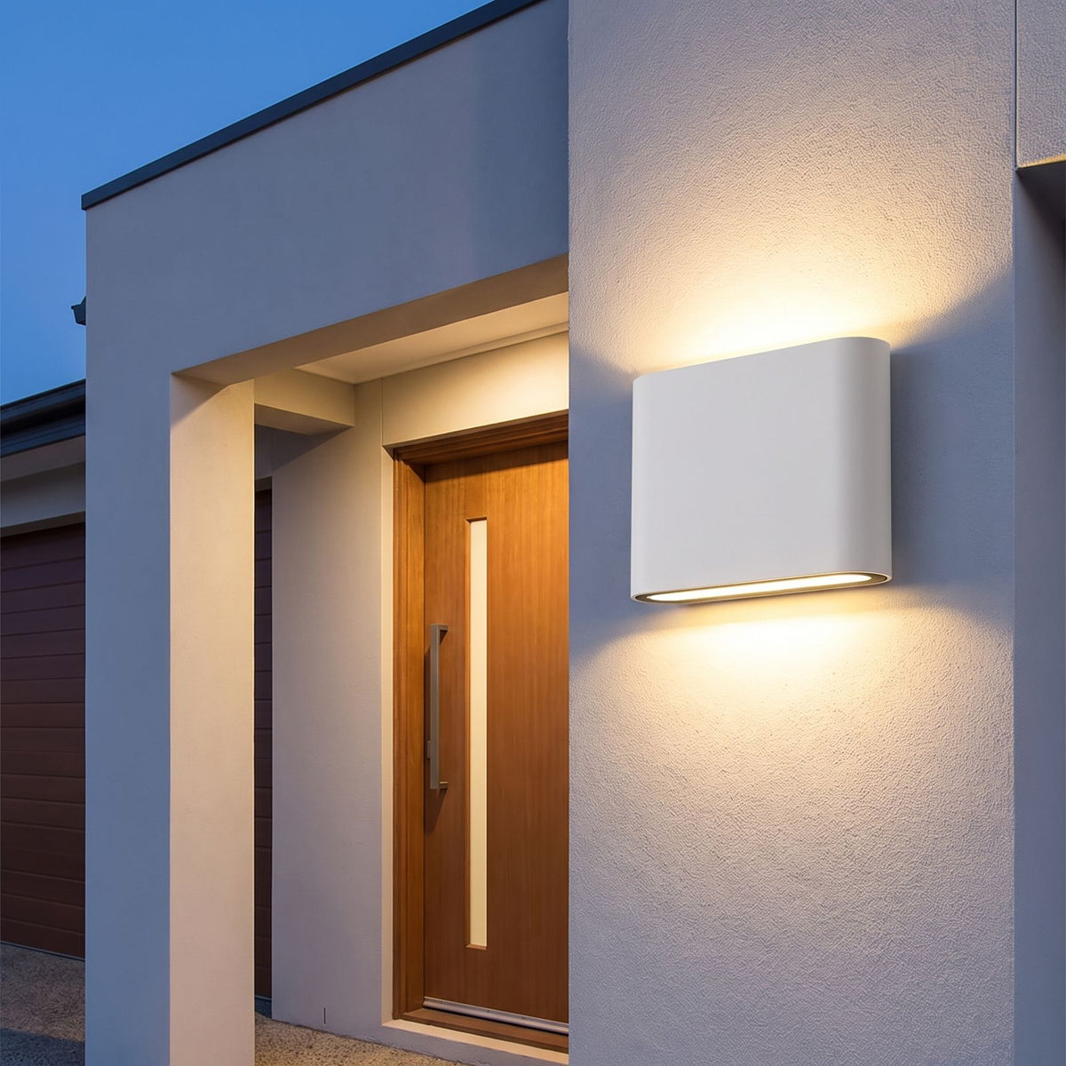 Rounded Box Aluminium Up Down Outdoor Wall Light beside a timber front door at dusk