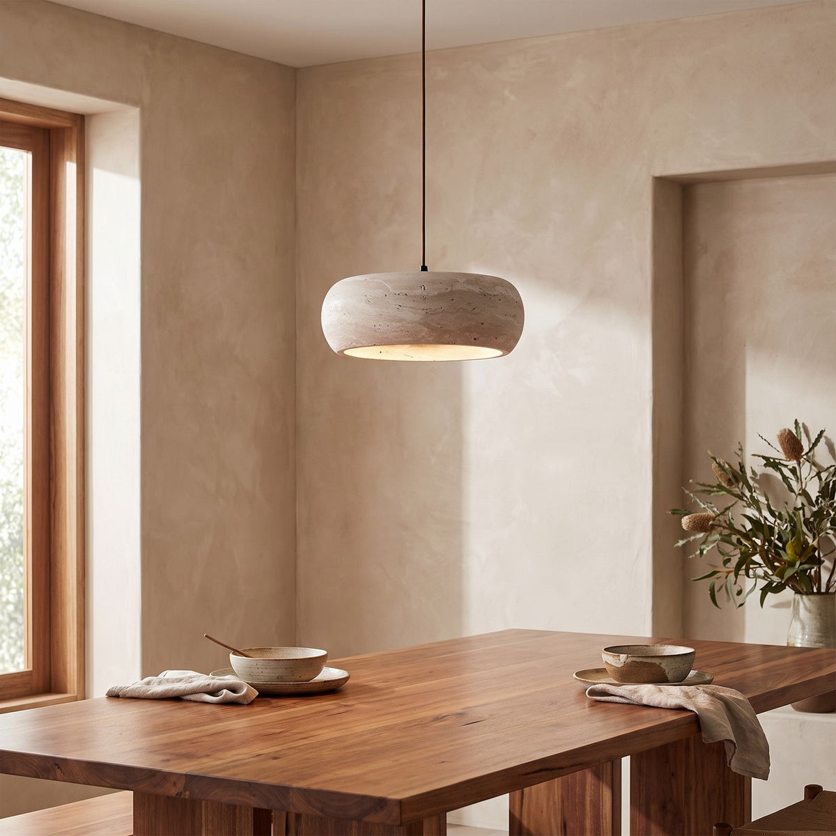 Rounded Travertine Puck LED Pendant Light above a timber dining table