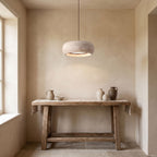Rounded Travertine Puck LED Pendant Light above a console in an entry hallway