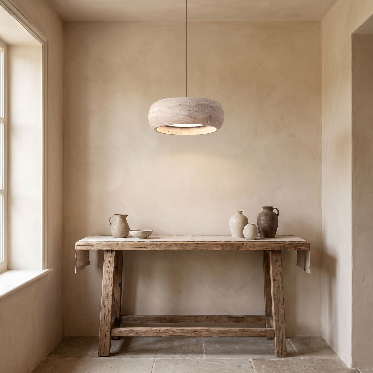 Rounded Travertine Puck LED Pendant Light above a console in an entry hallway