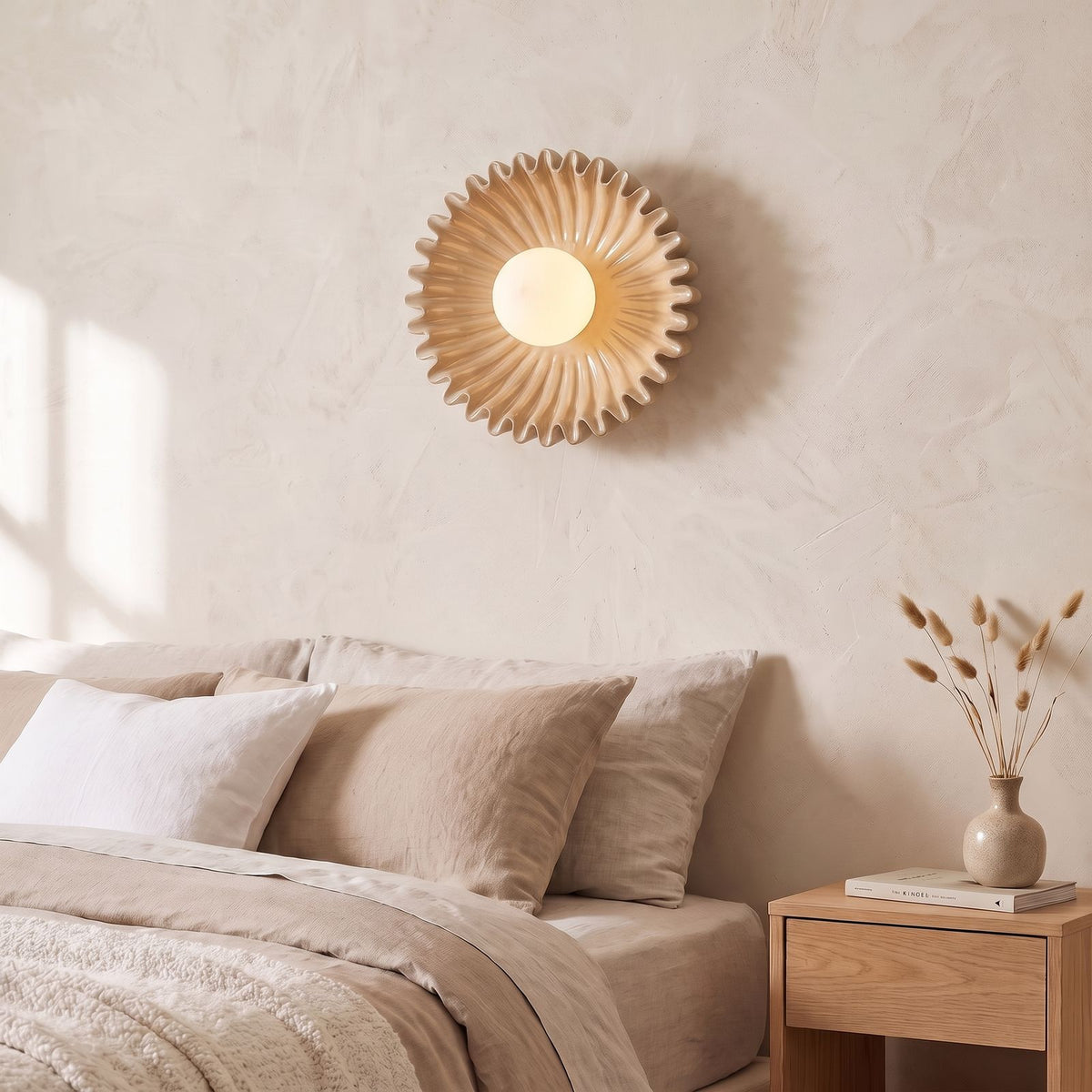 Ruffled Ceramic Flower Wall Light in beige beside a bed