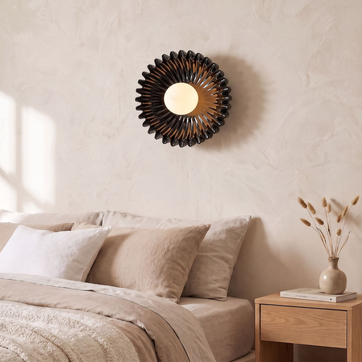Ruffled Ceramic Flower Wall Light in black beside a bed