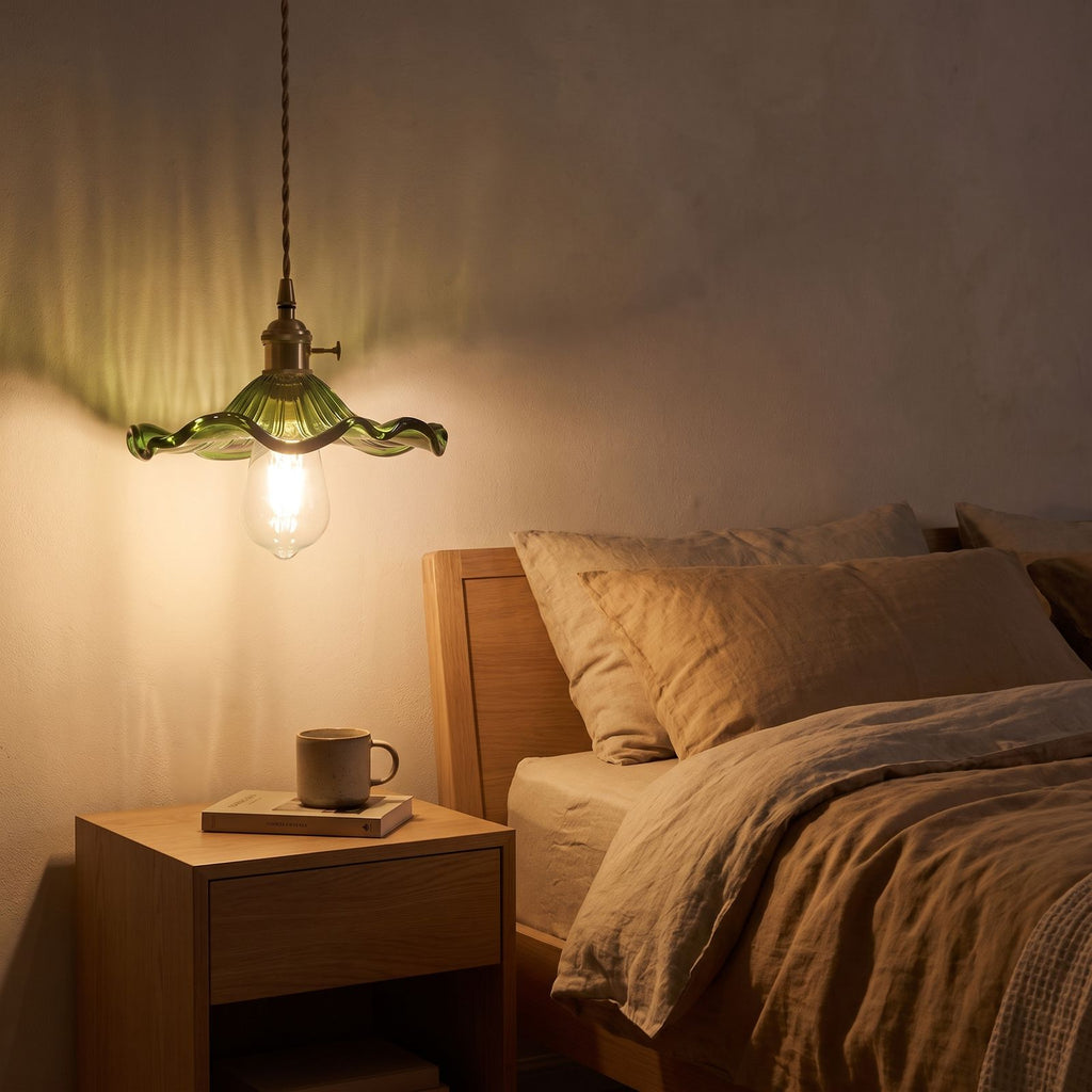 Ruffled fluted glass pendant light over a bedside table at night