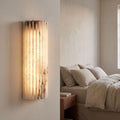 Scalloped Alabaster Half-Cylinder LED Wall Sconce beside a bed