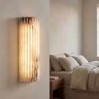 Scalloped Alabaster Half-Cylinder LED Wall Sconce beside a bed