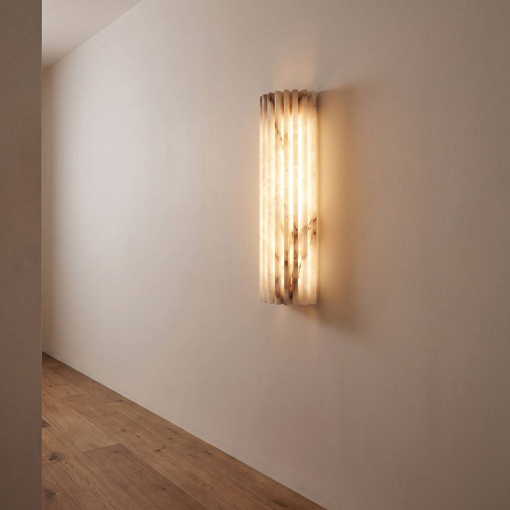 Scalloped alabaster half-cylinder wall sconce on a hallway wall