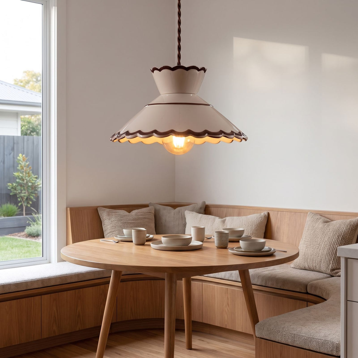 Scalloped cream ceramic pendant light over a breakfast nook table