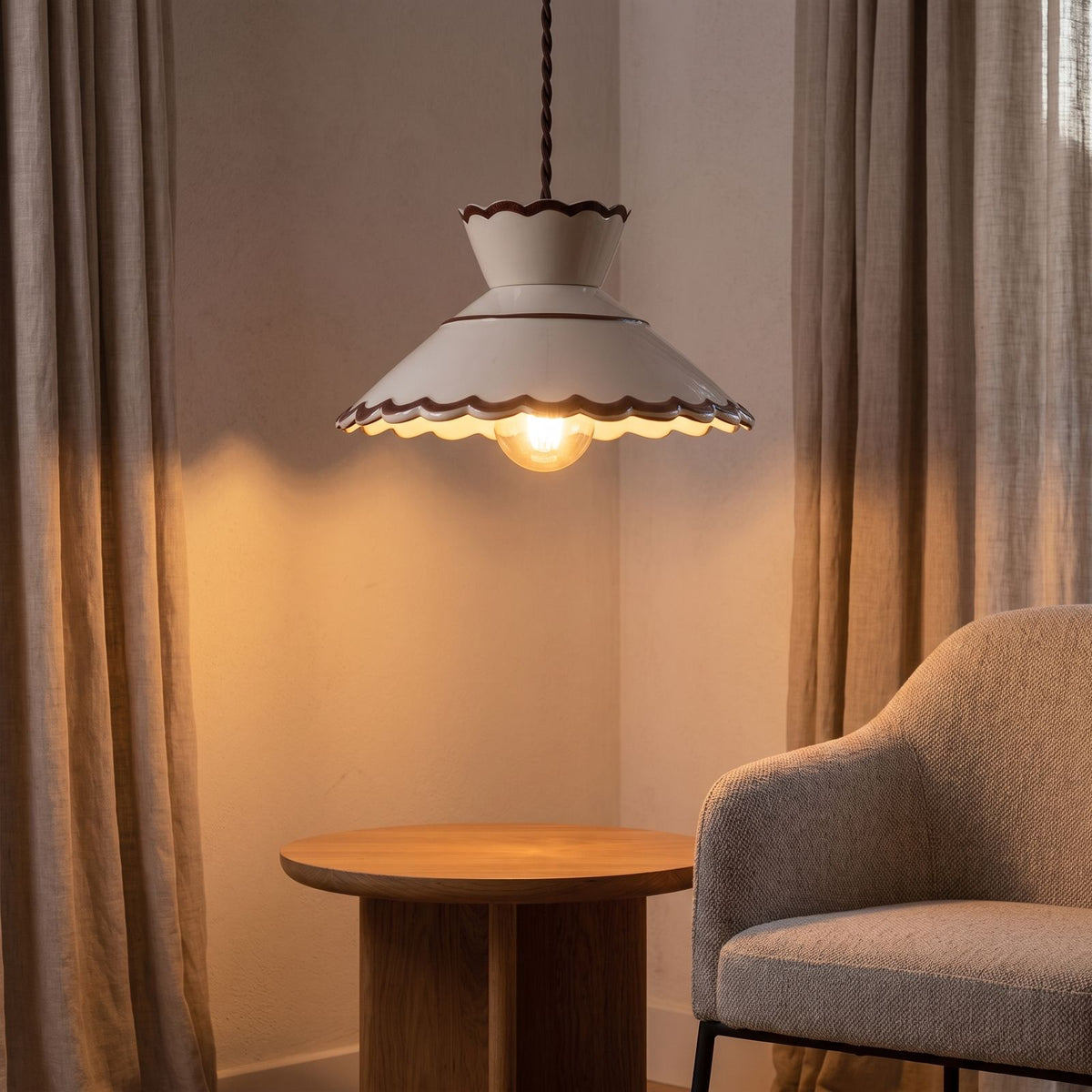 Scalloped cream ceramic pendant light over a side table in a living room corner
