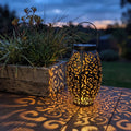 Scroll Pattern Metal Lantern Solar Garden Light on a timber deck at dusk