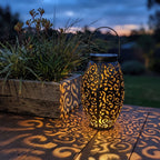 Scroll Pattern Metal Lantern Solar Garden Light on a timber deck at dusk