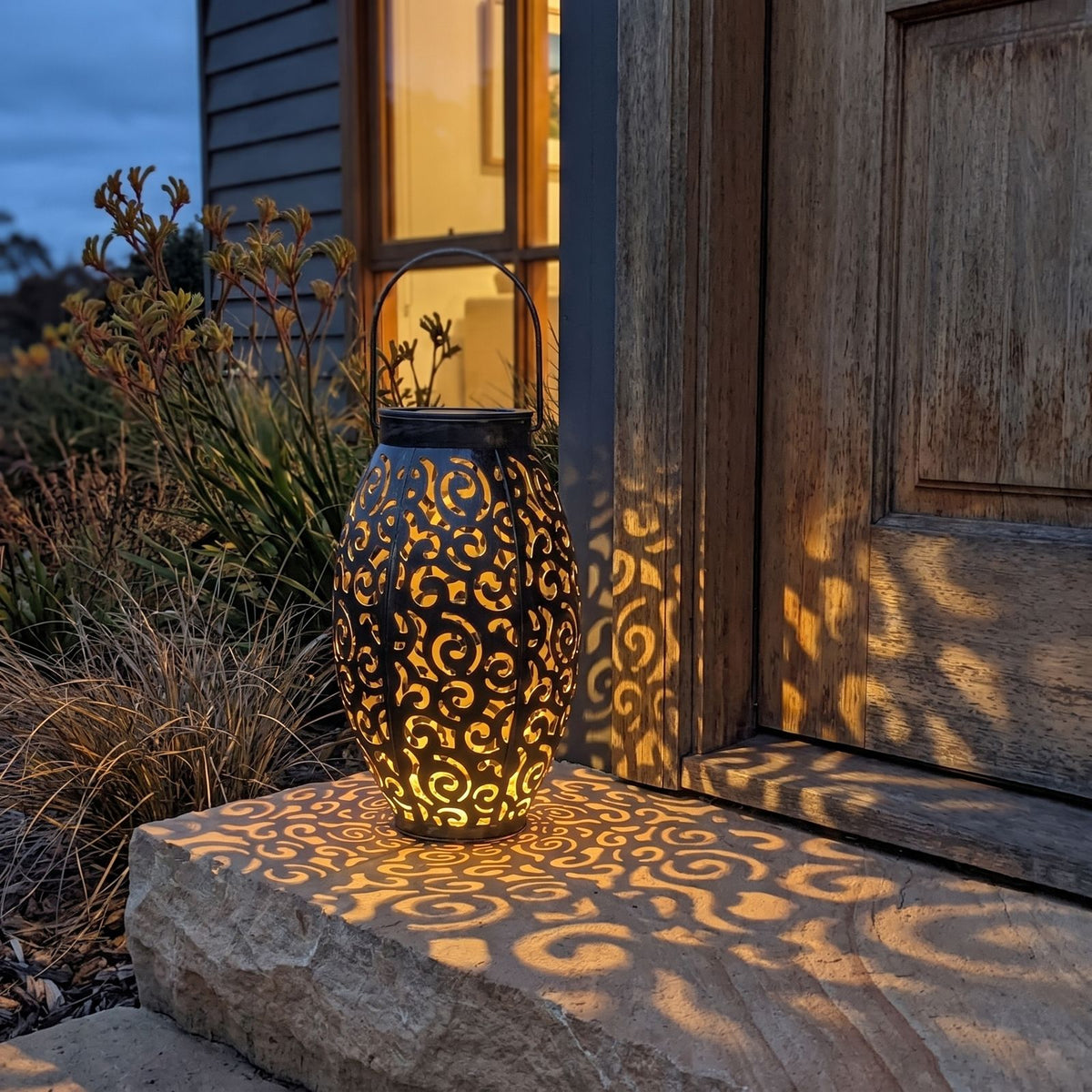 Scroll pattern metal solar lantern on a front door step