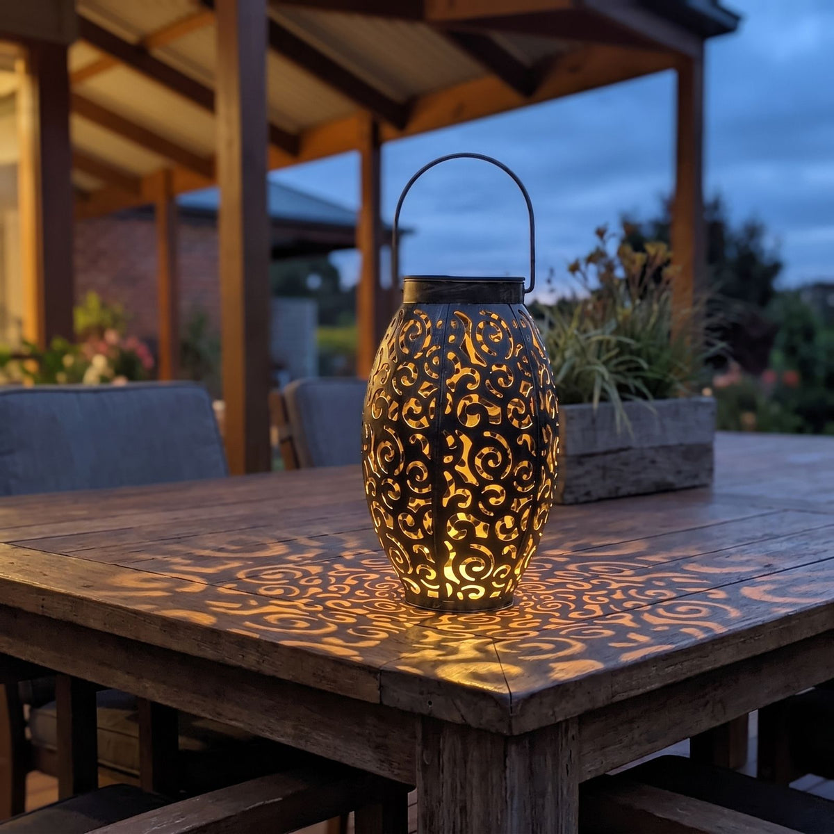 Scroll pattern metal solar lantern on an outdoor dining table
