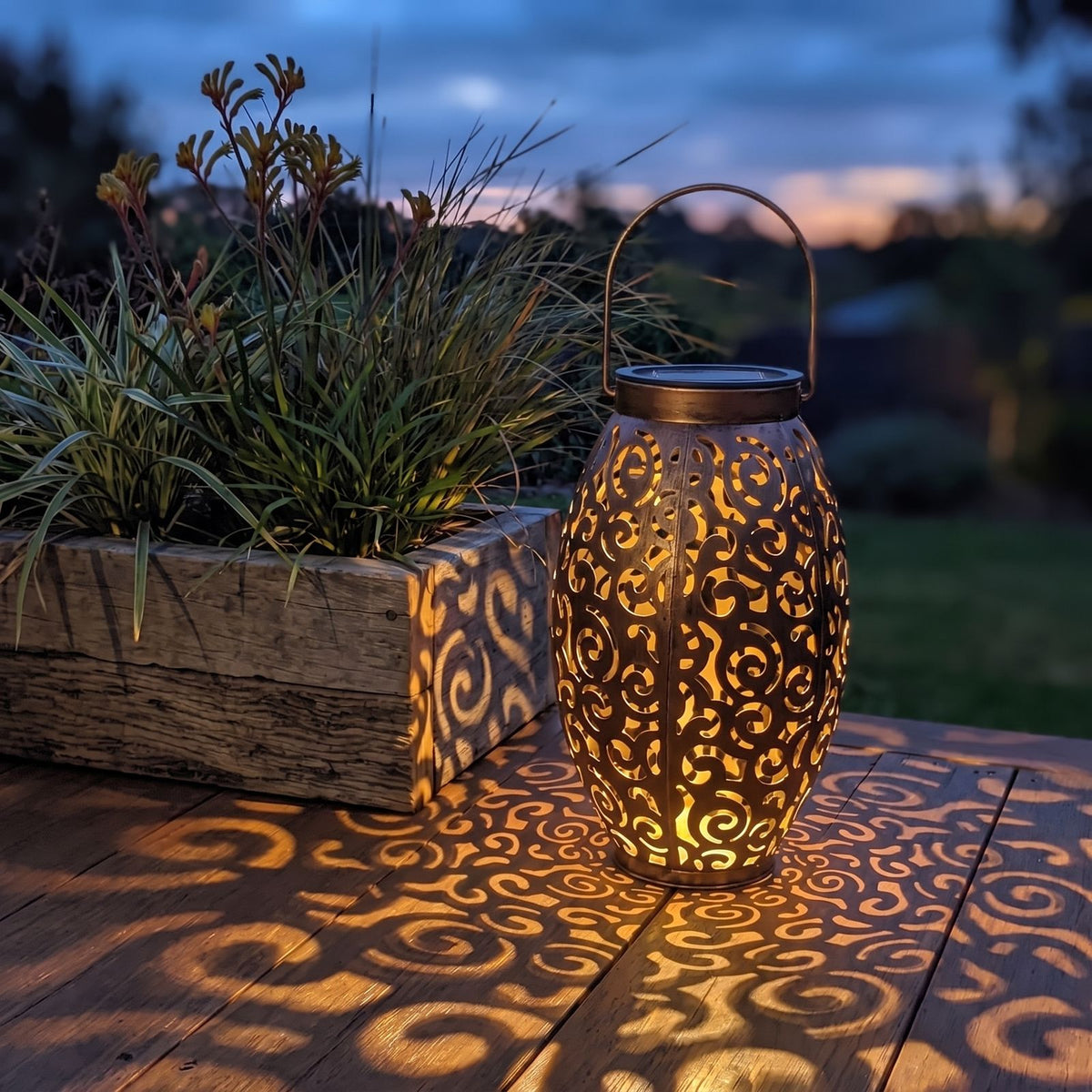 Scroll Pattern Metal Lantern Solar Garden Light in brown on a timber deck at dusk