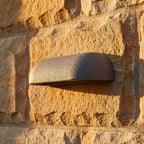 Semi Oval Stone Outdoor Wall Light, close view at 45 degrees on a stone wall