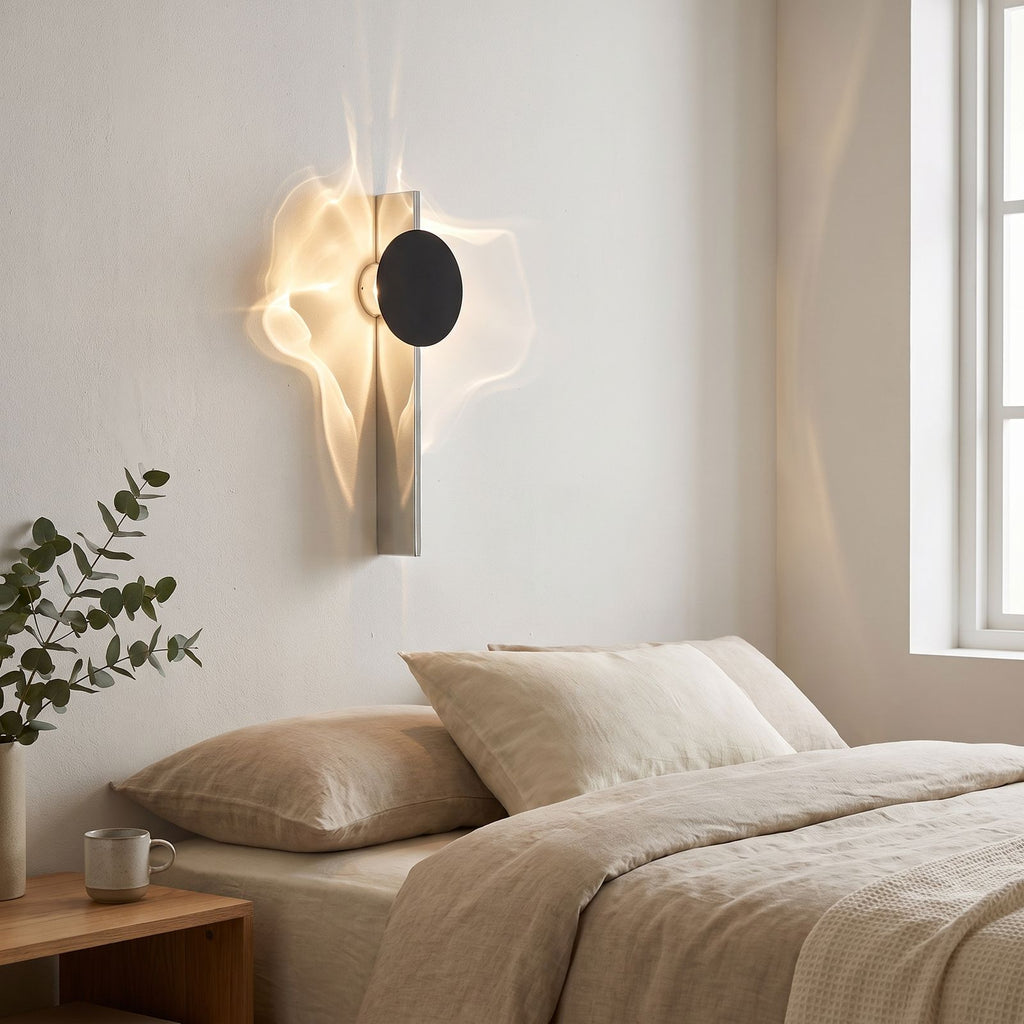 Shadow Casting Aluminium and Glass Wall Light on a bedroom wall beside the bed