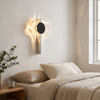 Shadow Casting Aluminium and Glass Wall Light on a bedroom wall beside the bed