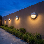 A row of Silver Bulkhead Outdoor Wall Lights along a rendered garden wall at dusk