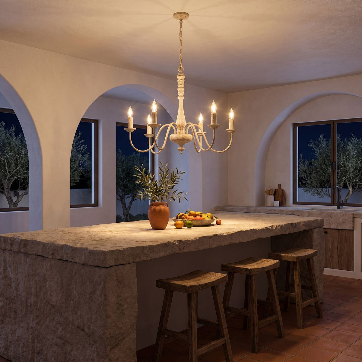 Six Arm Distressed Candle Chandelier above a kitchen island at night