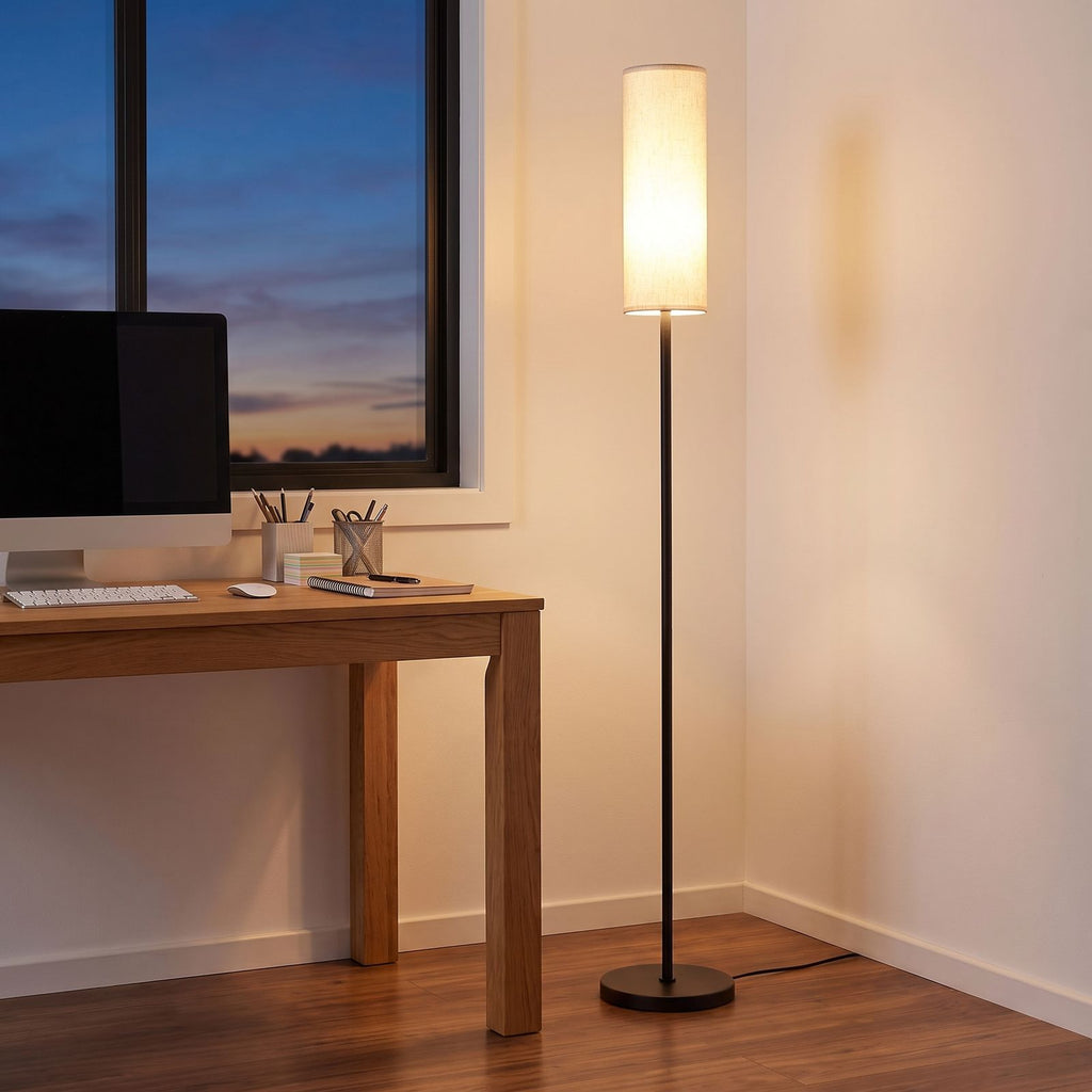 Fabric cylinder shade floor lamp in a home office corner beside a desk