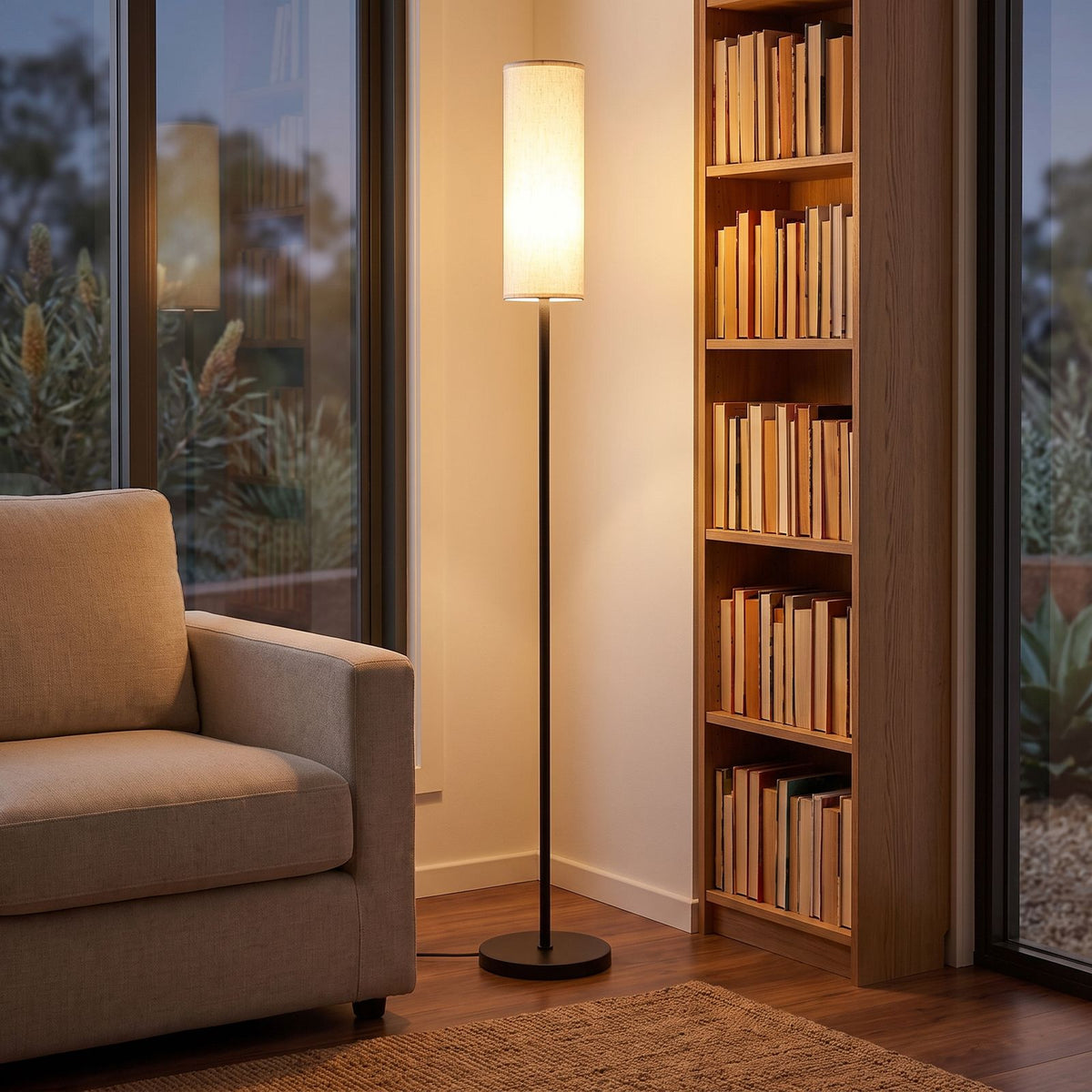 Fabric cylinder shade floor lamp in a reading corner beside a bookshelf