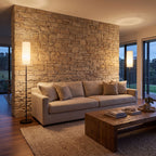 A pair of slim black floor lamps at each end of a sofa in a living room with a stone feature wall