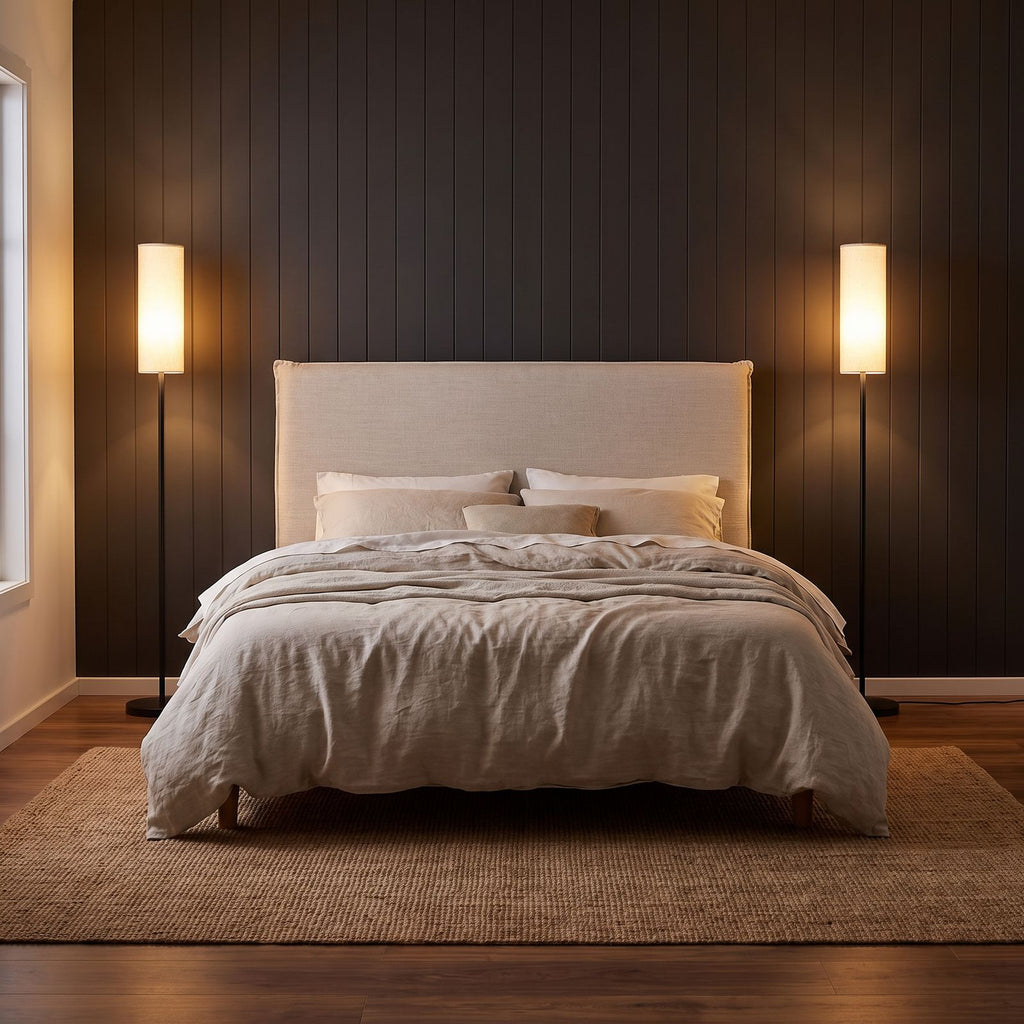 A pair of slim black floor lamps either side of a king bed in an elegant bedroom