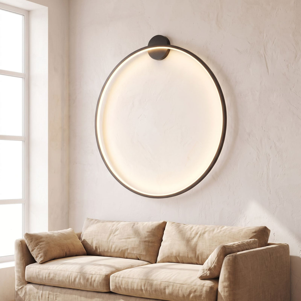 Slim black ring backlit LED wall light above a living room sofa in daylight