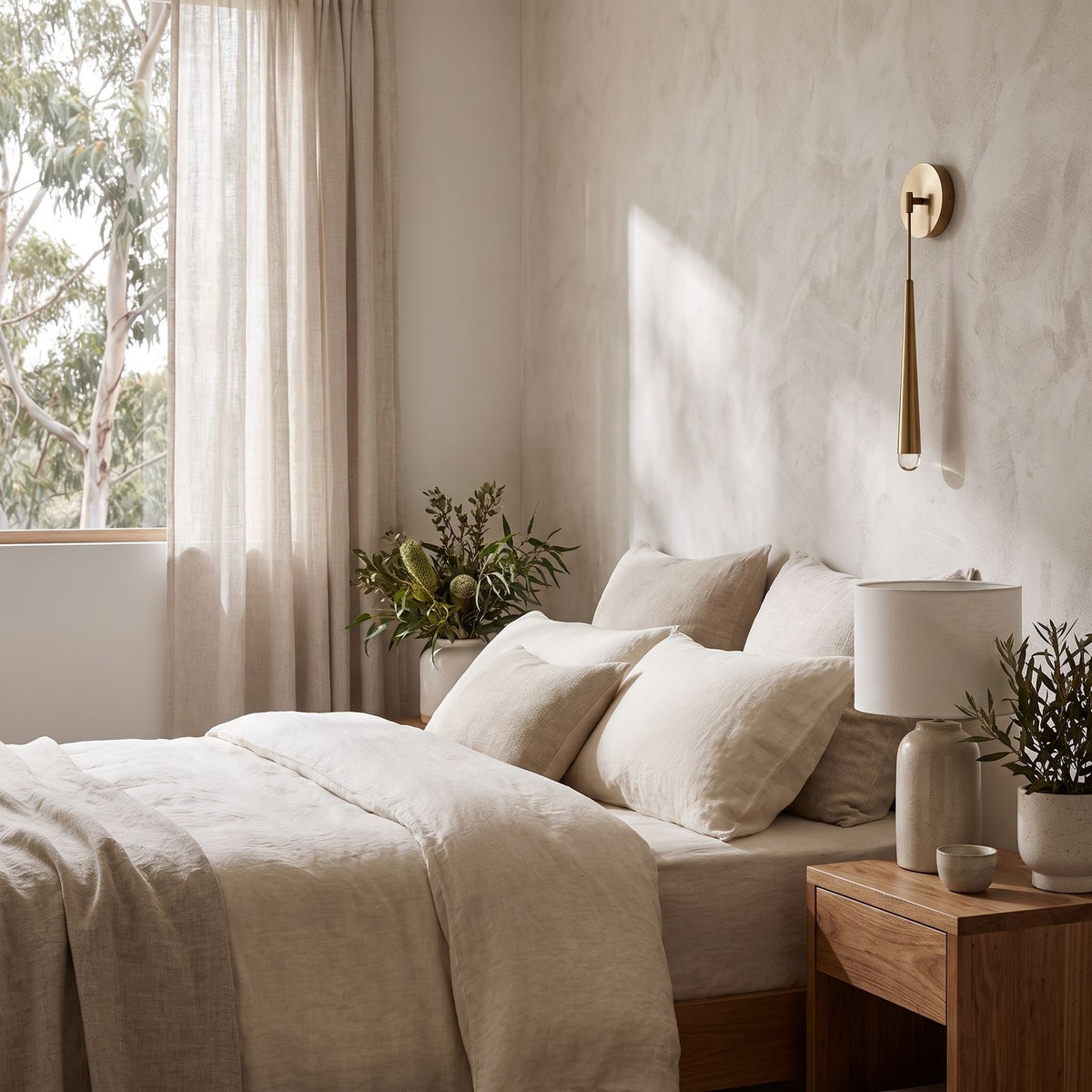 Slim Brass Teardrop Wall Sconce on a bedroom wall beside the bed