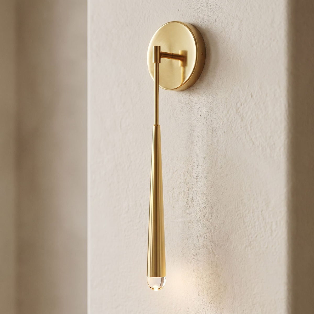 Slim Brass Teardrop Wall Sconce, close view at 45 degrees on a plaster wall