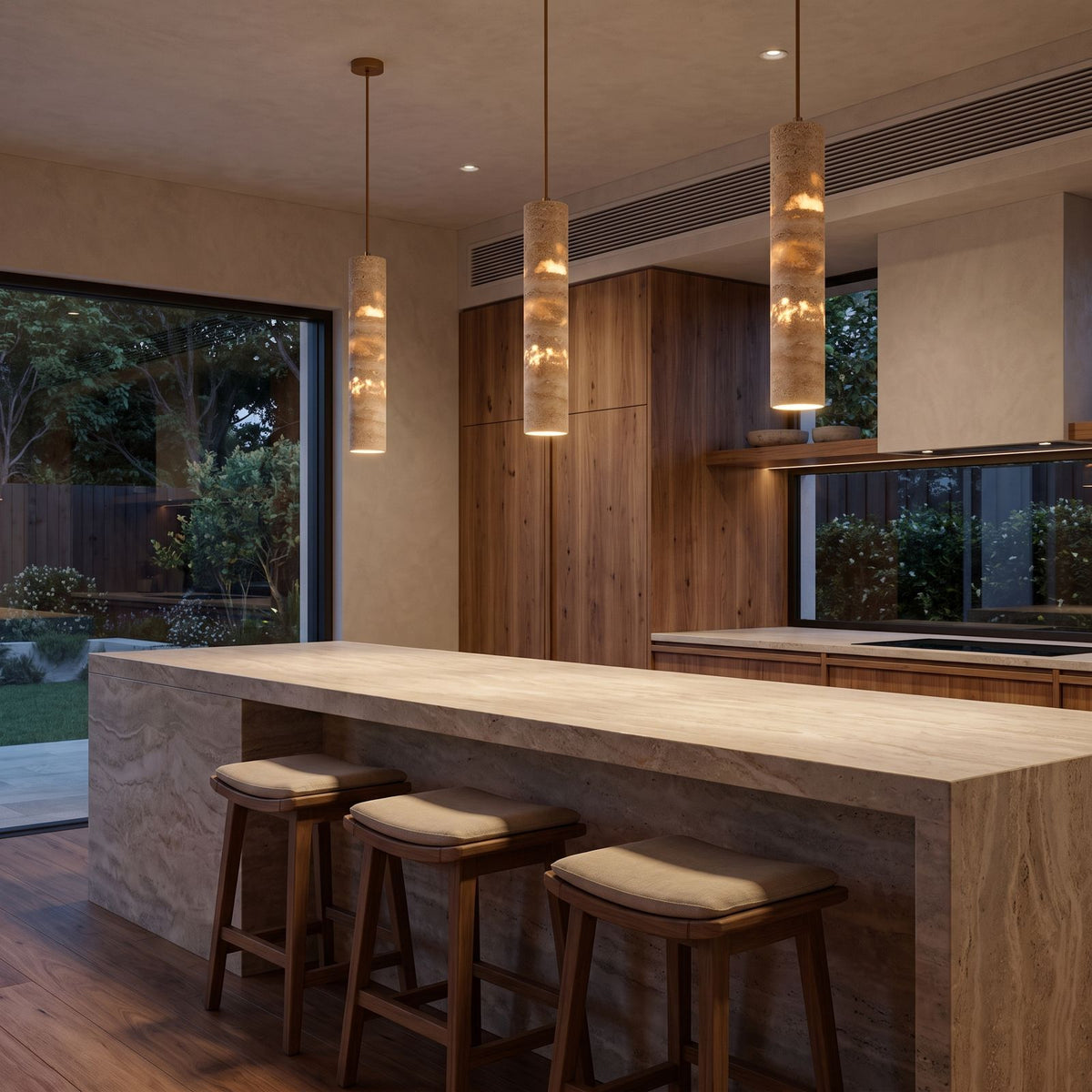 A row of three Slim Cream Marble Tube LED Pendant Lights over a stone kitchen island