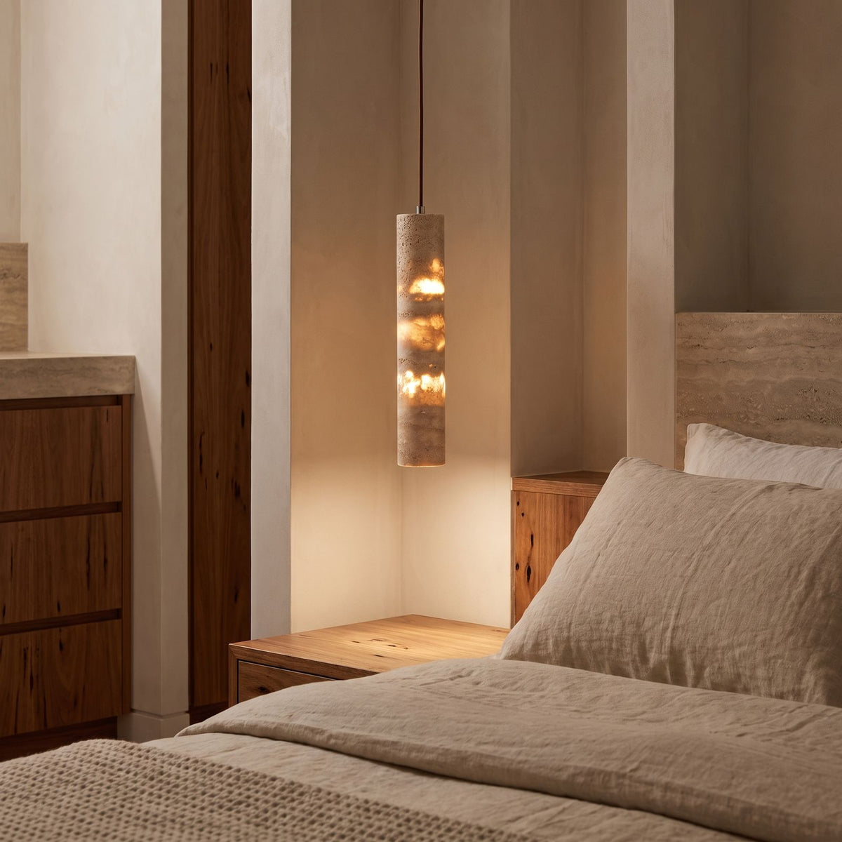 Slim Cream Marble Tube LED Pendant Light hanging beside a bed