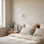 Slim Crystal Disc LED Wall Light on a bedroom wall beside the bed